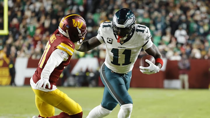 Dec 20, 2025; Landover, Maryland, USA; Philadelphia Eagles wide receiver A.J. Brown (11) carries the ball as Washington Commanders cornerback Jonathan Jones (31) defends during the first half at Northwest Stadium.