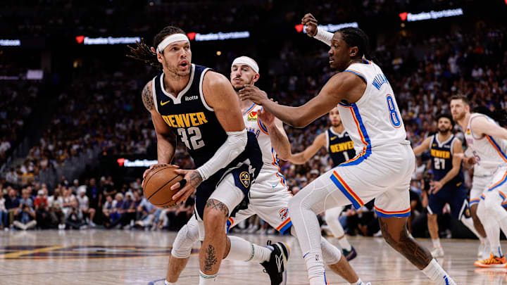 May 11, 2025; Denver, Colorado, USA; Denver Nuggets forward Aaron Gordon (32) controls the ball under pressure from Oklahoma City Thunder forward Jalen Williams (8) and guard Alex Caruso (9) in the fourth quarter during game four of the second round of the 2025 NBA Playoffs at Ball Arena. Mandatory Credit: Isaiah J. Downing-Imagn Images