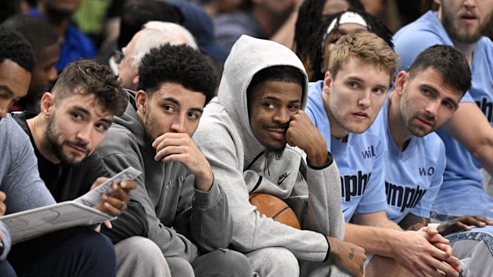 Nov 22, 2025; Dallas, Texas, USA; Memphis Grizzlies guard Ja Morant (center) looks on from the team bench during the first quarter against the Dallas Mavericks at the American Airlines Center. Mandatory Credit: Jerome Miron-Imagn Images