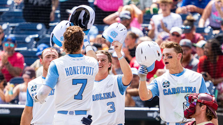Jun 18, 2024; Omaha, NE, USA; North Carolina Tar Heels center fielder Vance Honeycutt (7) celebrates with second baseman Alex Madera (1), shortstop Colby Wilkerson (3) and first baseman Parks Harber (14) after hitting a three-run home run against the Florida State Seminoles during the fifth inning at Charles Schwab Field Omaha. 