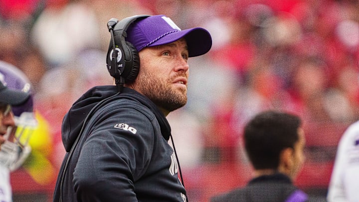 Oct 25, 2025; Lincoln, Nebraska, USA; Northwestern Wildcats head coach David Braun watches a replay during the second quarter against the Nebraska Cornhuskers at Memorial Stadium. Mandatory Credit: Dylan Widger-Imagn Images
