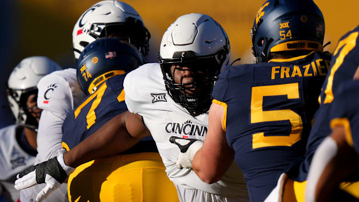 Cincinnati Bearcats defensive lineman Dontay Corleone (2) rushes the quarterback as West Virginia Mountaineers offensive lineman Zach Frazier (54) blocks in the first quarter during an NCAA college football game between the Cincinnati Bearcats and the West Virginia Mountaineers, Saturday, Nov. 18, 2023, at Milan Puskar Stadium in Morgantown, W. Va.