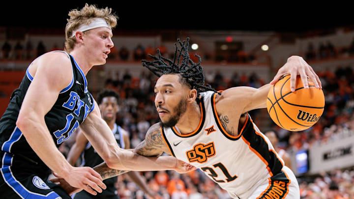 Feb 4, 2026; Stillwater, Oklahoma, USA; Oklahoma State Cowboys guard Isaiah Coleman (21) drives around BYU Cougars guard Richie Saunders (15) during the first half at Gallagher-Iba Arena. Mandatory Credit: William Purnell-Imagn Images'