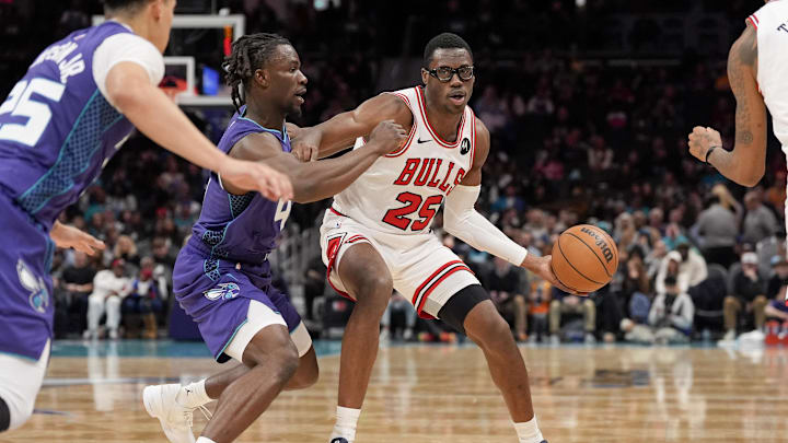 Dec 12, 2025; Charlotte, North Carolina, USA; Chicago Bulls forward Jalen Smith (25) handles the ball against Charlotte Hornets guard Sion James (4) during the second half at Spectrum Center. Mandatory Credit: Jim Dedmon-Imagn Images