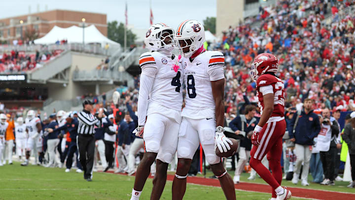 Oct 25, 2025; Fayetteville, Arkansas, USA; Auburn Tigers wide receiver Cam Coleman (8) celebrates with wide receiver Malcolm Simmons (4) after scoring a touchdown defended by Arkansas Razorbacks defensive back Julian Neal (23) during the first quarter at Donald W. Reynolds Razorback Stadium. Mandatory Credit: Nelson Chenault-Imagn Images