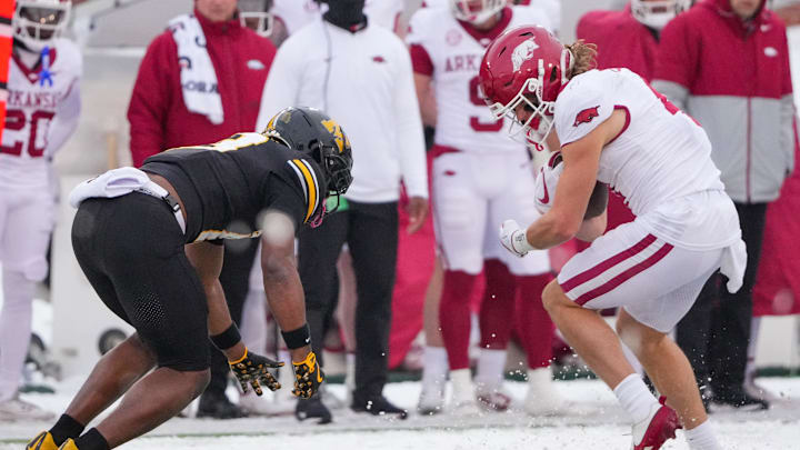 Nov 30, 2024; Columbia, Missouri, USA; Arkansas Razorbacks wide receiver Isaac TeSlaa (4) runs the hall as Missouri Tigers safety Daylan Carnell (13) makes the tackle during the first half at Faurot Field at Memorial Stadium. Mandatory Credit: Denny Medley-Imagn Images