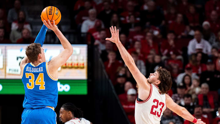 Jan 4, 2025; Lincoln, Nebraska, USA; UCLA Bruins forward Tyler Bilodeau (34) shoots a three-point basket against Nebraska Cornhuskers forward Andrew Morgan (23) during the first half at Pinnacle Bank Arena. Mandatory Credit: Dylan Widger-Imagn Images