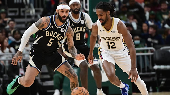 Apr 10, 2025; Milwaukee, Wisconsin, USA; New Orleans Pelicans guard Antonio Reeves (12) and Milwaukee Bucks guard Gary Trent Jr. (5) chase a loose ball in the third quarter at Fiserv Forum. Mandatory Credit: Benny Sieu-Imagn Images