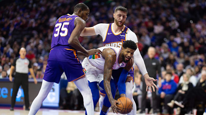 Jan 6, 2025; Philadelphia, Pennsylvania, USA; Philadelphia 76ers forward Paul George (8) controls the ball against Phoenix Suns forward Kevin Durant (35) and center Jusuf Nurkic (20) during the first quarter at Wells Fargo Center. Mandatory Credit: Bill Streicher-Imagn Images