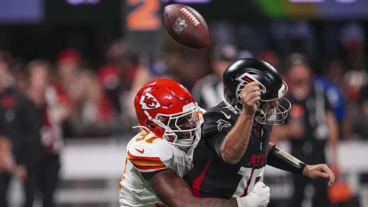 Sep 22, 2024; Atlanta, Georgia, USA; Atlanta Falcons quarterback Kirk Cousins (18) is hit by Kansas City Chiefs defensive end Felix Anudike-Uzomah (97) and fumbles the ball during the first half at Mercedes-Benz Stadium. Mandatory Credit: Dale Zanine-Imagn Images