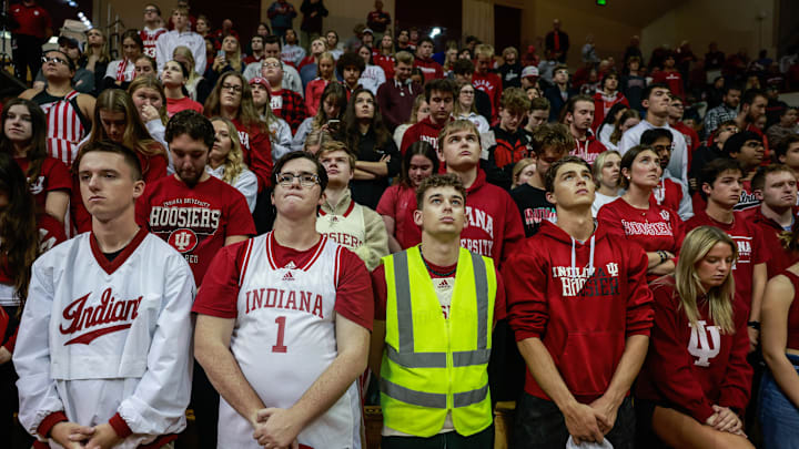 Basketball fans in the student section pause for a moment of...