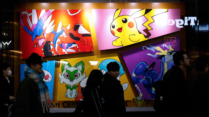 Customers walk past the Pokemon Store graffiti at Tokyo...
