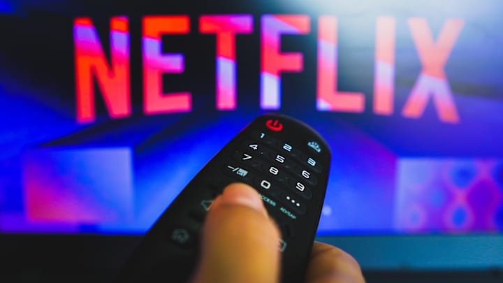 In this photo illustration, a hand holding a TV remote...