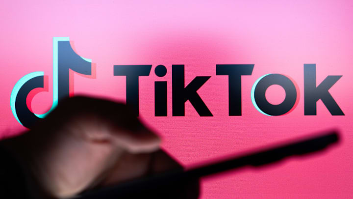 In this photo illustration the TikTok logo seen in the...