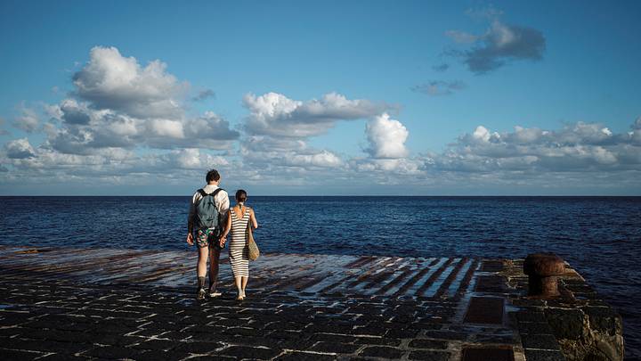A couple walks hand in hand on a pier A couple walks hand in hand on a pier