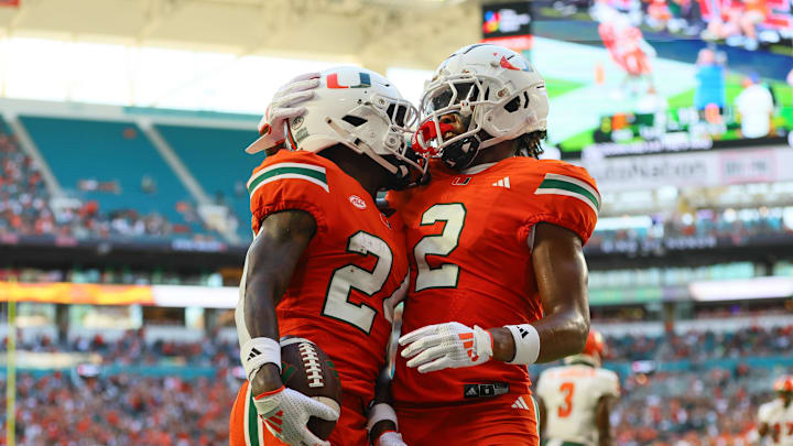 Sep 7, 2024; Miami Gardens, Florida, USA; Miami Hurricanes running back Chris Johnson Jr. (24) celebrates with wide receiver Isaiah Horton (2) after scoring a touchdown against Florida A&M Rattlers during the second quarter at Hard Rock Stadium. Mandatory Credit: Sam Navarro-Imagn Images