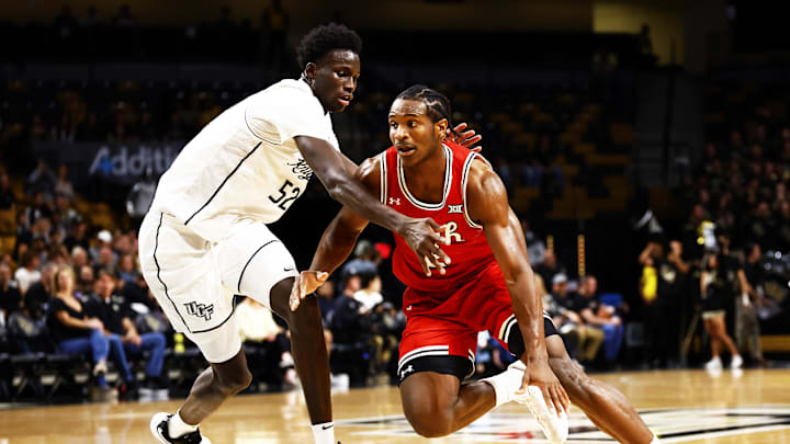Feb 23, 2025; Orlando, Florida, USA; Utah Utes forward Ezra Ausar (2) dribbles against Central Florida Knights center Moustapha Thiam (52) at Addition Financial Arena. Mandatory Credit: Russell Lansford-Imagn Images