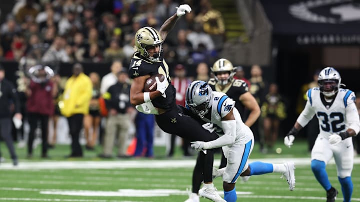 New Orleans Saints wide receiver Devaughn Vele (14) is tackled by Carolina Panthers cornerback Mike Jackson 
