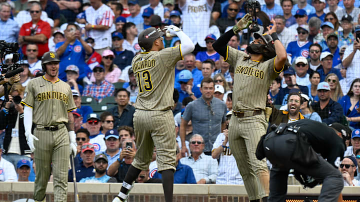Oct 1, 2025; Chicago, Illinois, USA; San Diego infielder Manny Machado (13) and Fernando Tatis Jr. (13) (right) celebrate at home plate after hitting a two-run home run in the fifth inning against the Chicago Cubs during game two of the Wildcard round for the 2025 MLB playoffs at Wrigley Field. 