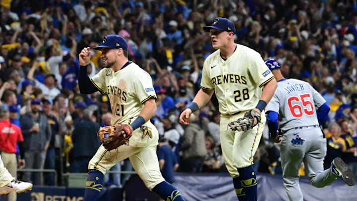 Oct 11, 2025; Milwaukee, Wisconsin, USA; Milwaukee Brewers third baseman Caleb Durbin (21) and first baseman Andrew Vaughn (28) celebrate after defeating the Chicago Cubs in game five of the NLDS round for the 2025 MLB playoffs at American Family Field. Mandatory Credit: Benny Sieu-Imagn Images
