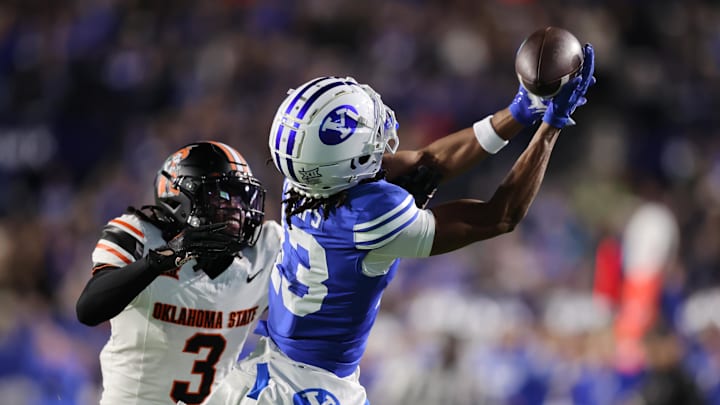Oct 18, 2024; Provo, Utah, USA; Brigham Young Cougars wide receiver Jojo Phillips (13) reaches for a pass against Oklahoma State Cowboys cornerback Cam Smith (3) during the first quarter at LaVell Edwards Stadium. Mandatory Credit: Rob Gray-Imagn Images Oct 18, 2024; Provo, Utah, USA; Brigham Young Cougars wide receiver Jojo Phillips (13) reaches for a pass against Oklahoma State Cowboys cornerback Cam Smith (3) during the first quarter at LaVell Edwards Stadium. Mandatory Credit: Rob Gray-Imagn Images