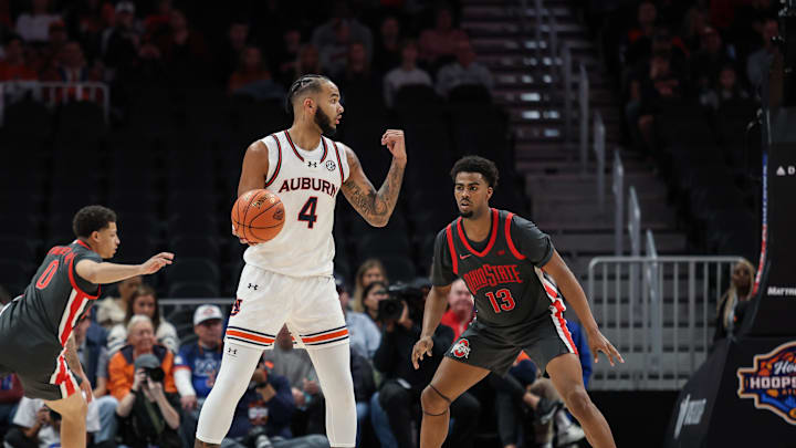 Dec 14, 2024; Atlanta, Georgia, USA; Auburn Tigers forward Johni Broome (4) signals for team against Ohio State Buckeyes forward Sean Stewart (13) during the second half at State Farm Arena. Mandatory Credit: Jordan Godfree-Imagn Images