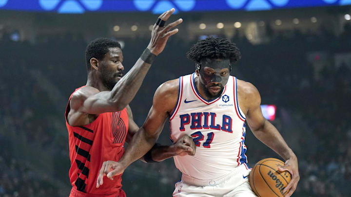 Dec 30, 2024; Portland, Oregon, USA; Philadelphia 76ers center Joel Embiid (21) handles the ball against Portland Trail Blazers center Deandre Ayton (2, left) during the first half at Moda Center. Mandatory Credit: Soobum Im-Imagn Images