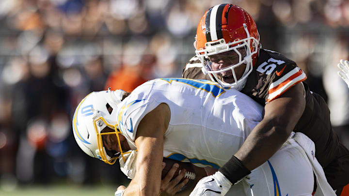 Nov 3, 2024; Cleveland, Ohio, USA; Cleveland Browns defensive tackle Mike Hall Jr. (51) tackles Los Angeles Chargers quarterback Justin Herbert (10) during the third quarter at Huntington Bank Field. Mandatory Credit: Scott Galvin-Imagn Images