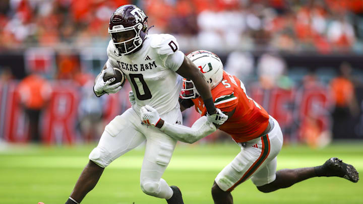 Sep 9, 2023; Miami Gardens, Florida, USA; Texas A&M Aggies wide receiver Ainias Smith (0) runs with the ball ahead of Miami Hurricanes safety Kamren Kinchens (5) during the first quarter at Hard Rock Stadium. Mandatory Credit: Sam Navarro-Imagn Images Sep 9, 2023; Miami Gardens, Florida, USA; Texas A&M Aggies wide receiver Ainias Smith (0) runs with the ball ahead of Miami Hurricanes safety Kamren Kinchens (5) during the first quarter at Hard Rock Stadium. Mandatory Credit: Sam Navarro-Imagn Images
