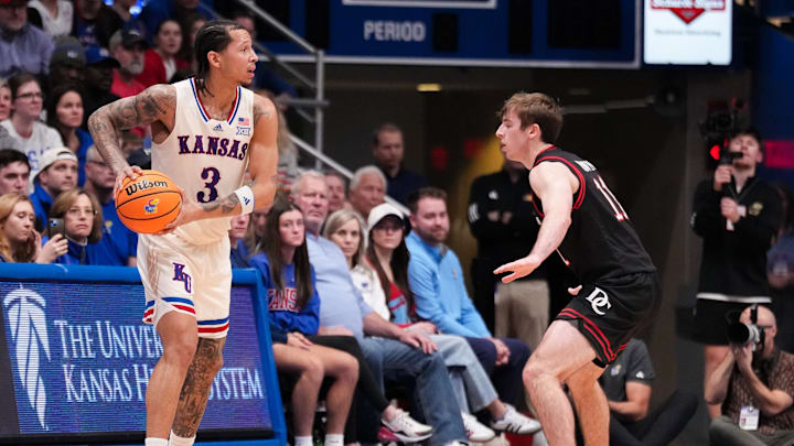 Dec 22, 2025; Lawrence, Kansas, USA; Kansas Jayhawks guard Tre White (3) controls the ball as Davidson Wildcats guard Sam Brown (11) defends during the first half of the game at Allen Fieldhouse. Mandatory Credit: Denny Medley-Imagn Images