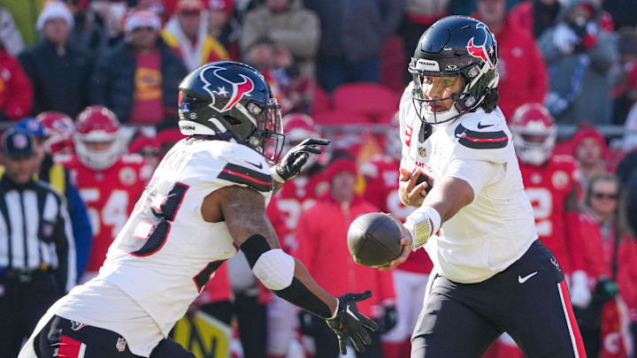 Dec 21, 2024; Kansas City, Missouri, USA; Houston Texans quarterback C.J. Stroud (7) hands off to running back Joe Mixon (28) against the Kansas City Chiefs during the first half at GEHA Field at Arrowhead Stadium. Mandatory Credit: Denny Medley-Imagn Images