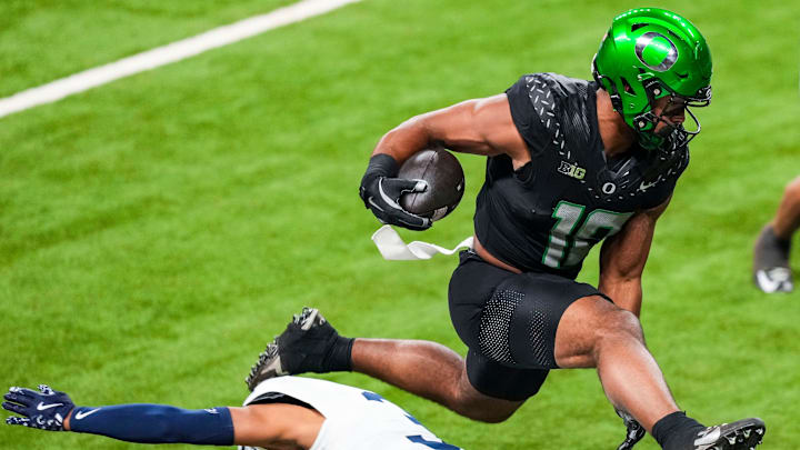 Oregon Ducks tight end Kenyon Sadiq (18) hurdles over Penn State Nittany Lions cornerback Jalen Kimber (3) on Saturday, Dec. 7, 2024, during the Big Ten Championship game between the Oregon Ducks and the Penn State Nittany Lions at Lucas Oil Stadium in Indianapolis.