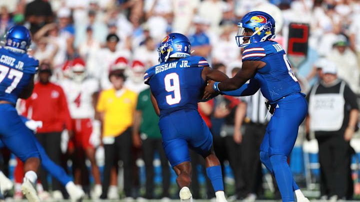Kansas Jayhawks quarterback Jalon Daniels (6) hands off the ball to Kansas Jayhawks running back Daniel Hishaw Jr. (9) during the game between Fresno State and Kansas at David Booth Kansas Memorial Stadium on Aug. 23, 2025.
