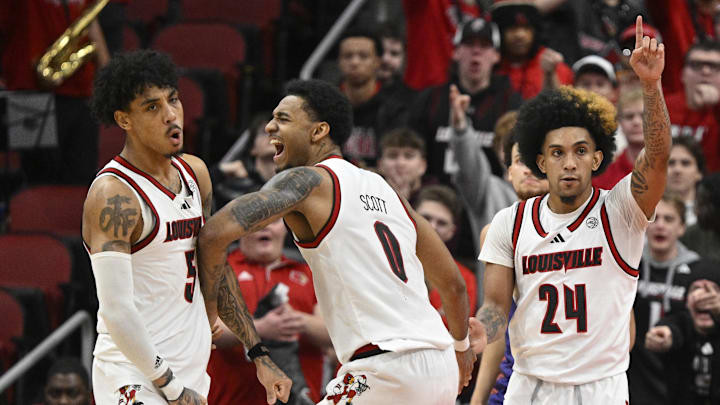 Jan 7, 2025; Louisville, Kentucky, USA; Louisville Cardinals forward James Scott (0) celebrates with guard Terrence Edwards Jr. (5) and guard Chucky Hepburn (24) during the second half against the Clemson Tigers at KFC Yum! Center. Louisville defeated Clemson 74-64.