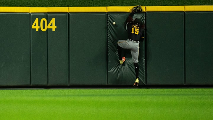 Pittsburg Pirates center fielder Oneil Cruz (15) hits the wall as Cincinnati Reds right fielder Noelvi Marte (16) scores on an inside the park home run in the eighth inning between Cincinnati Reds and Pittsburg Pirates at Great American Ball Park in Cincinnati on Sept. 24, 2025.