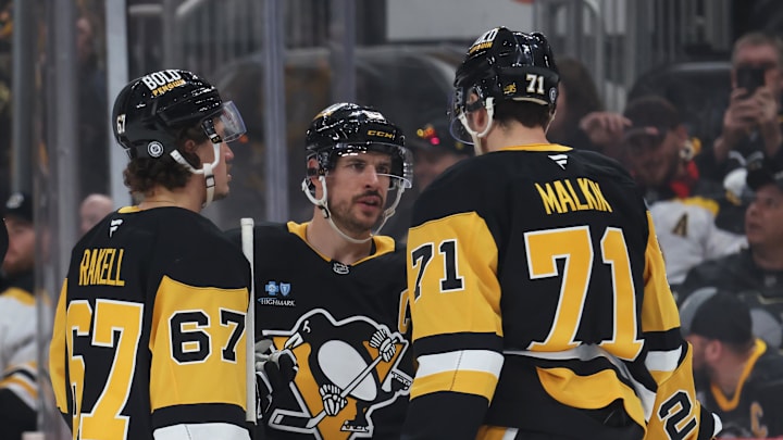 Apr 13, 2025; Pittsburgh, Pennsylvania, USA;  Pittsburgh Penguins right wing Rickard Rakell (67) and center Sidney Crosby (87) and center Evgeni Malkin (71) talk before a face-off against the Boston Bruins during the third period at PPG Paints Arena. Mandatory Credit: Charles LeClaire-Imagn Images