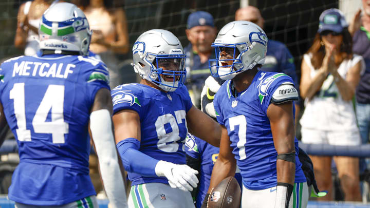 Sep 8, 2024; Seattle, Washington, USA; Seattle Seahawks quarterback Geno Smith (7) celebrates with tight end Noah Fant (87) after rushing for a touchdown against the Denver Broncos during the second quarter at Lumen Field. Mandatory Credit: Joe Nicholson-Imagn Images