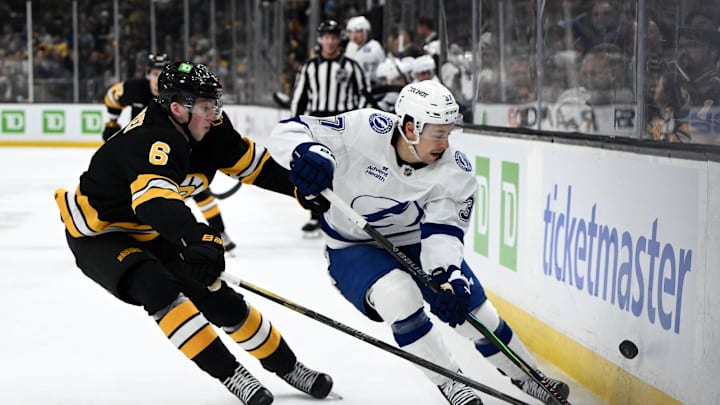 Apr 11, 2026; Boston, Massachusetts, USA; Tampa Bay Lightning center Yanni Gourde (37) and Boston Bruins defenseman Mason Lohrei (6) batted for the puck  during the second period at the TD Garden. Mandatory Credit: Brian Fluharty-Imagn Images