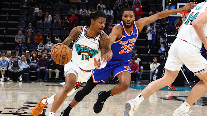 Feb 28, 2025; Memphis, Tennessee, USA; Memphis Grizzlies guard Ja Morant (12) drives to the basket as New York Knicks forward Mikal Bridges (25) defends during the third quarter at FedExForum. Mandatory Credit: Petre Thomas-Imagn Images