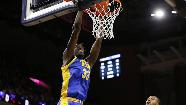 Feb 13, 2024; Charlottesville, Virginia, USA; Pittsburgh Panthers center Federiko Federiko (33) dunks the ball past Virginia Cavaliers forward Jordan Minor (22) during the first half at John Paul Jones Arena. Mandatory Credit: Amber Searls-Imagn Images