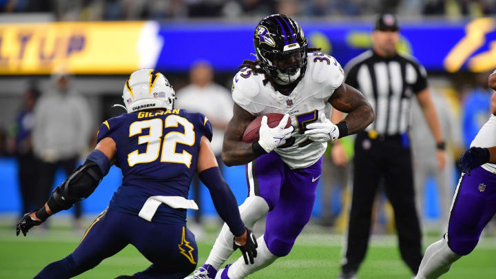 Nov 26, 2023; Inglewood, California, USA; Baltimore Ravens running back Gus Edwards (35) runs the ball against Los Angeles Chargers safety Alohi Gilman (32) during the first half at SoFi Stadium. Mandatory Credit: Gary A. Vasquez-USA TODAY Sports