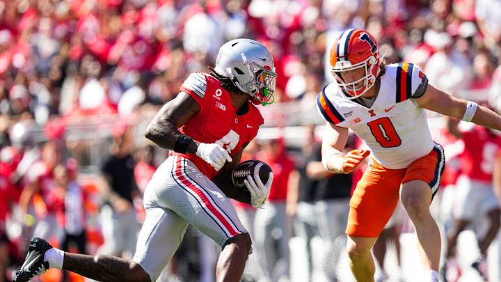 Ohio State Buckeyes wide receiver Jeremiah Smith (4) runs the ball against Illinois Fighting Illini defensive back Mac Resetich (0) in the first half of the NCAA football game at Ohio Stadium on Sept. 26, 2026 in Columbus, Ohio.