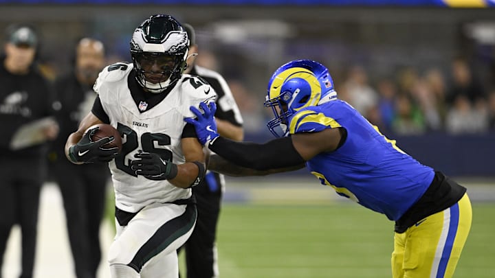 Nov 24, 2024; Inglewood, California, USA;  Philadelphia Eagles running back Saquon Barkley (26) gets pushed out-of-bound by Los Angeles Rams linebacker Jared Verse (right) during the first half at SoFi Stadium. Mandatory Credit: Alex Gallardo-Imagn Images