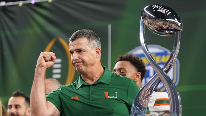 Dec 31, 2025; Arlington, TX, USA; Miami Hurricanes head coach Mario Cristobal with the champions trophy following the 2025 Cotton Bowl and quarterfinal game of the College Football Playoff against the Ohio State Buckeyes at AT&T Stadium. Mandatory Credit: Raymond Carlin III-Imagn Images Dec 31, 2025; Arlington, TX, USA; Miami Hurricanes head coach Mario Cristobal with the champions trophy following the 2025 Cotton Bowl and quarterfinal game of the College Football Playoff against the Ohio State Buckeyes at AT&T Stadium. Mandatory Credit: Raymond Carlin III-Imagn Images