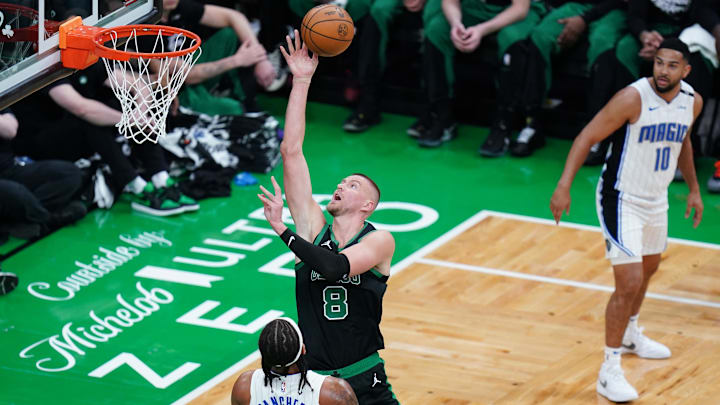 Apr 29, 2025; Boston, Massachusetts, USA; Boston Celtics center Kristaps Porzingis (8) makes the basket against Orlando Magic forward Paolo Banchero (5) in the first quarter during game five of first round for the 2025 NBA Playoffs at TD Garden. Mandatory Credit: David Butler II-Imagn Images