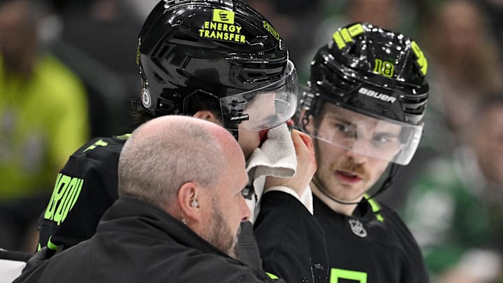Feb 2, 2025; Dallas, Texas, USA; Dallas Stars center Mavrik Bourque (22) is helped off the ice after getting hit in the face by a puck as center Sam Steel (18) looks on during the third period against the Columbus Blue Jackets at the American Airlines Center. Mandatory Credit: Jerome Miron-Imagn Images