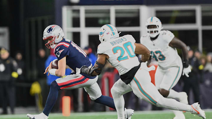 Jan 4, 2026; Foxborough, Massachusetts, USA; New England Patriots quarterback Drake Maye (10) scrambles against Miami Dolphins linebacker Jordyn Brooks (20) during the second quarter at Gillette Stadium. Mandatory Credit: Brian Fluharty-Imagn Images