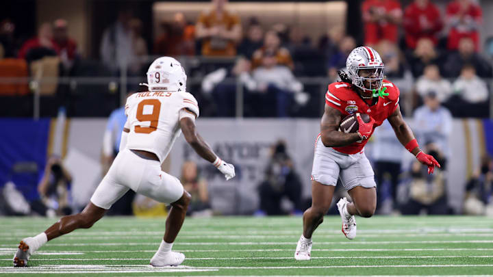 Jan 10, 2025; Arlington, Texas, USA; Ohio State Buckeyes running back Quinshon Judkins (1) runs against Texas Longhorns defensive back Gavin Holmes (9) during the first quarter of the College Football Playoff semifinal in the Cotton Bowl at AT&T Stadium. Mandatory Credit: Tim Heitman-Imagn Images