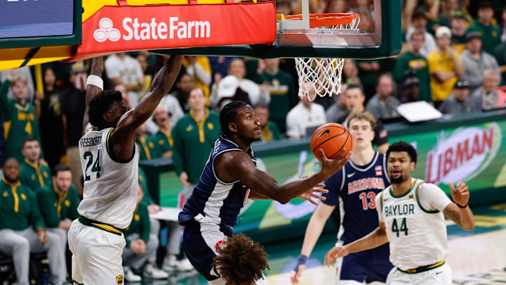 Feb 24, 2026; Waco, Texas, USA;  Arizona Wildcats guard Jaden Bradley (0) scores a reverse layup ahead of Baylor Bears guard Tounde Yessoufou (24) during the first half at Paul and Alejandra Foster Pavilion. Mandatory Credit: Chris Jones-Imagn Images