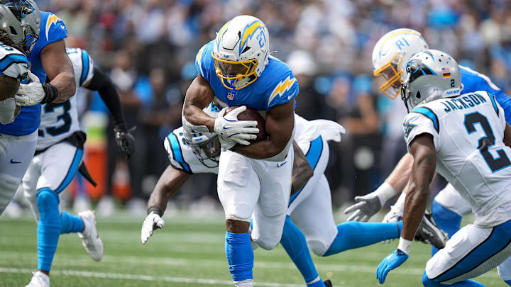 Sep 15, 2024; Charlotte, North Carolina, USA; Los Angeles Chargers running back J.K. Dobbins (27) runs up the middle chased by Carolina Panthers cornerback Michael Jackson (2) during the second quarter at Bank of America Stadium. Mandatory Credit: Jim Dedmon-Imagn Images